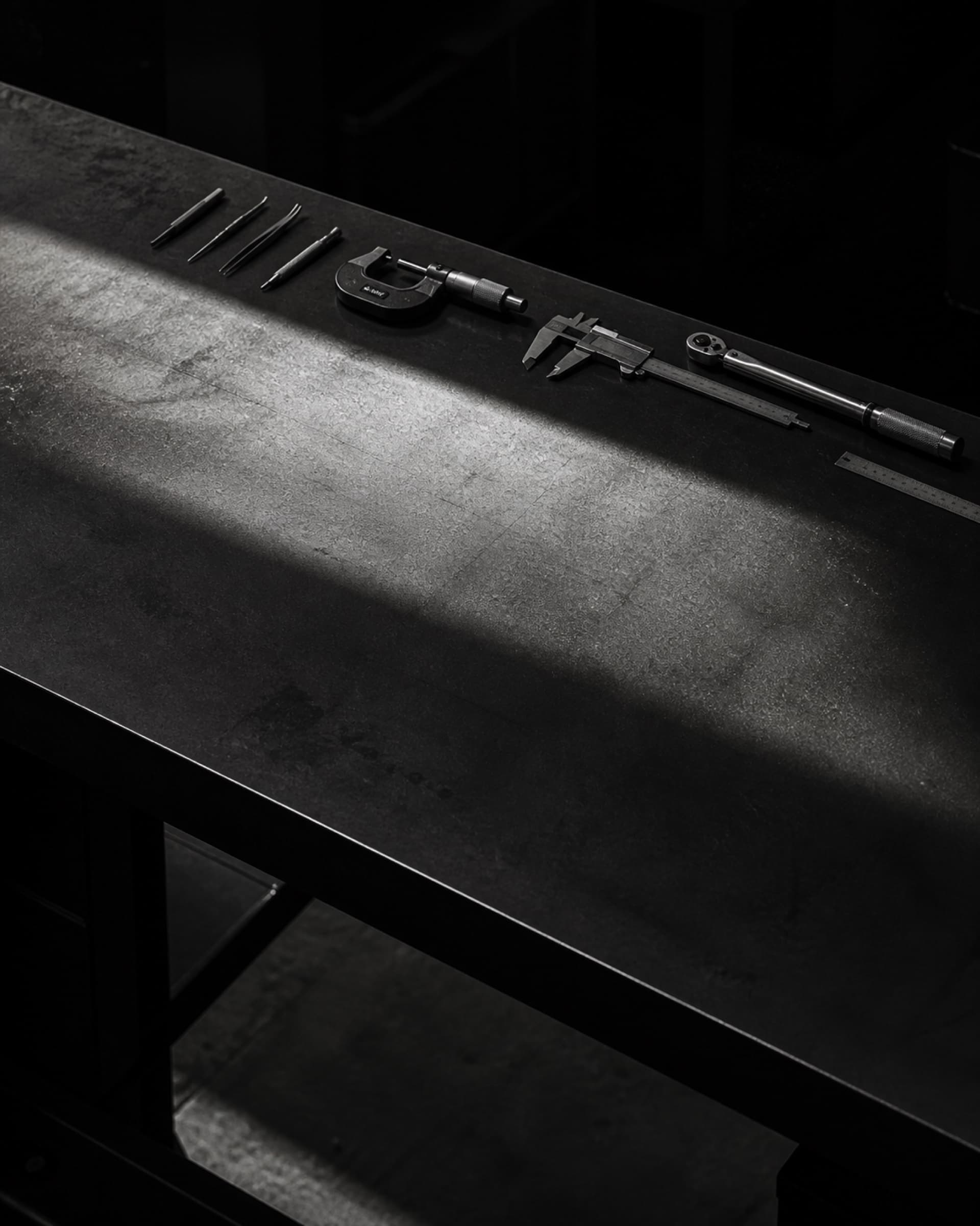 An empty workbench with hand tools arranged along its back edge.