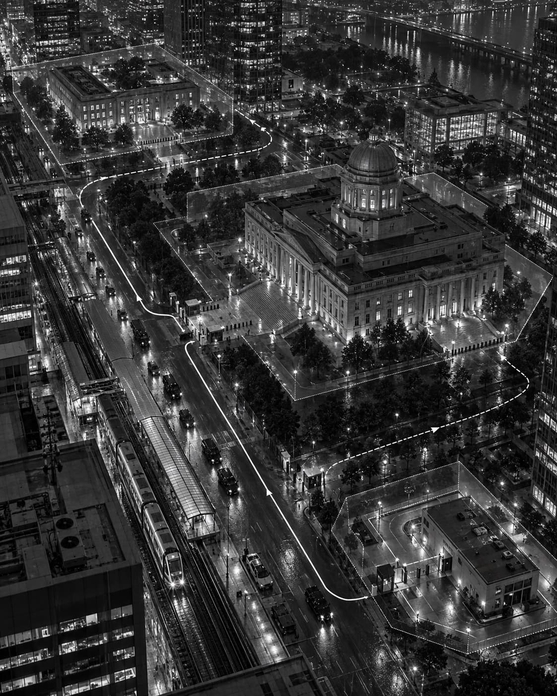 A night aerial of a civic district with routes traced in light.