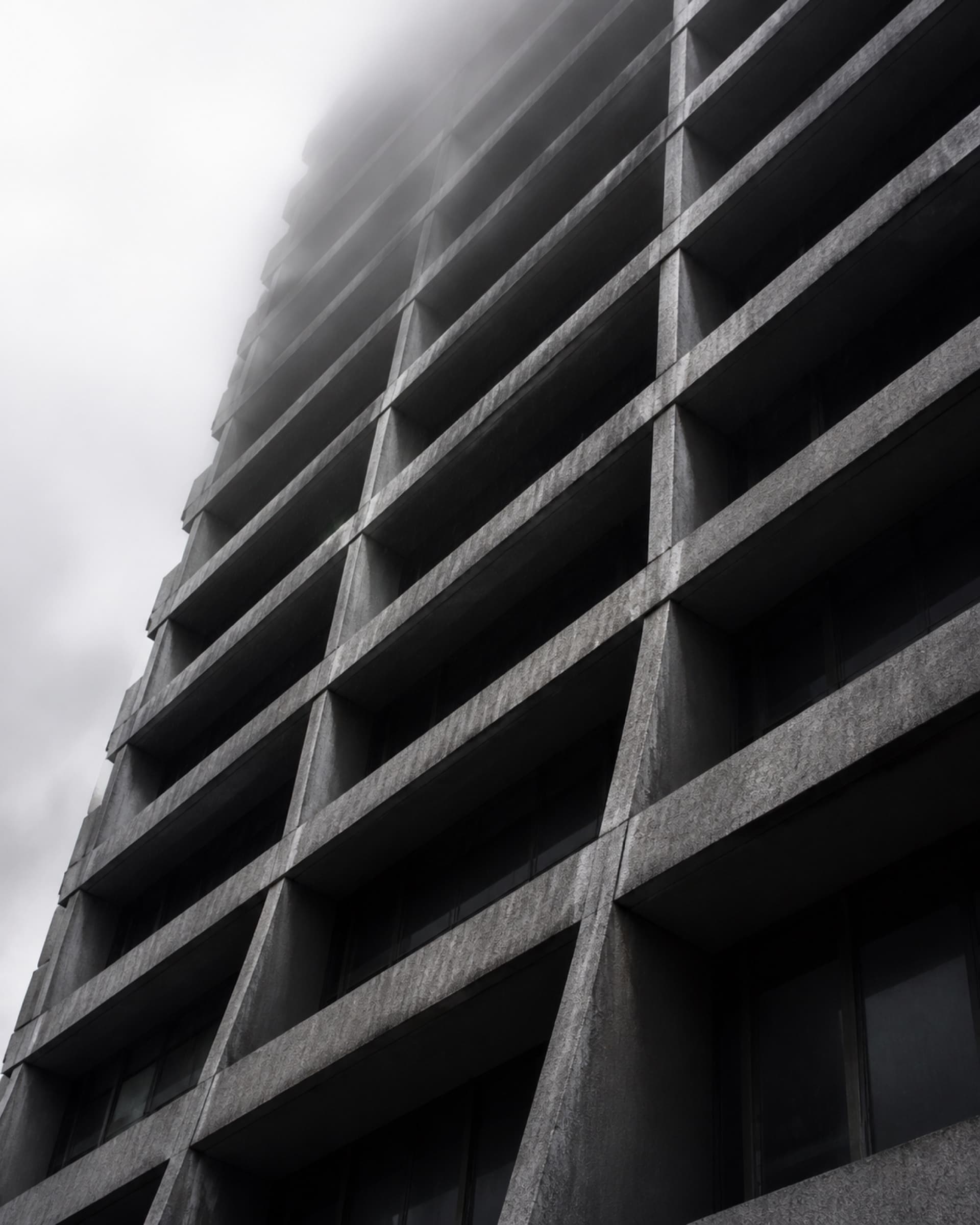 The upper floors of a commercial building seen against an overcast sky.