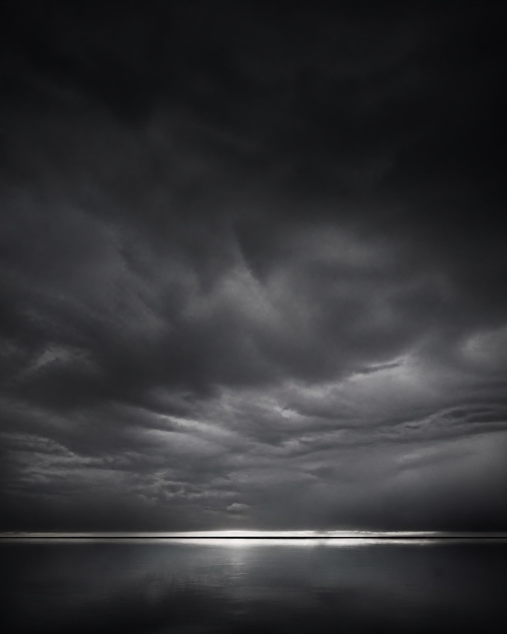 A long horizon seen across water in flat early light.