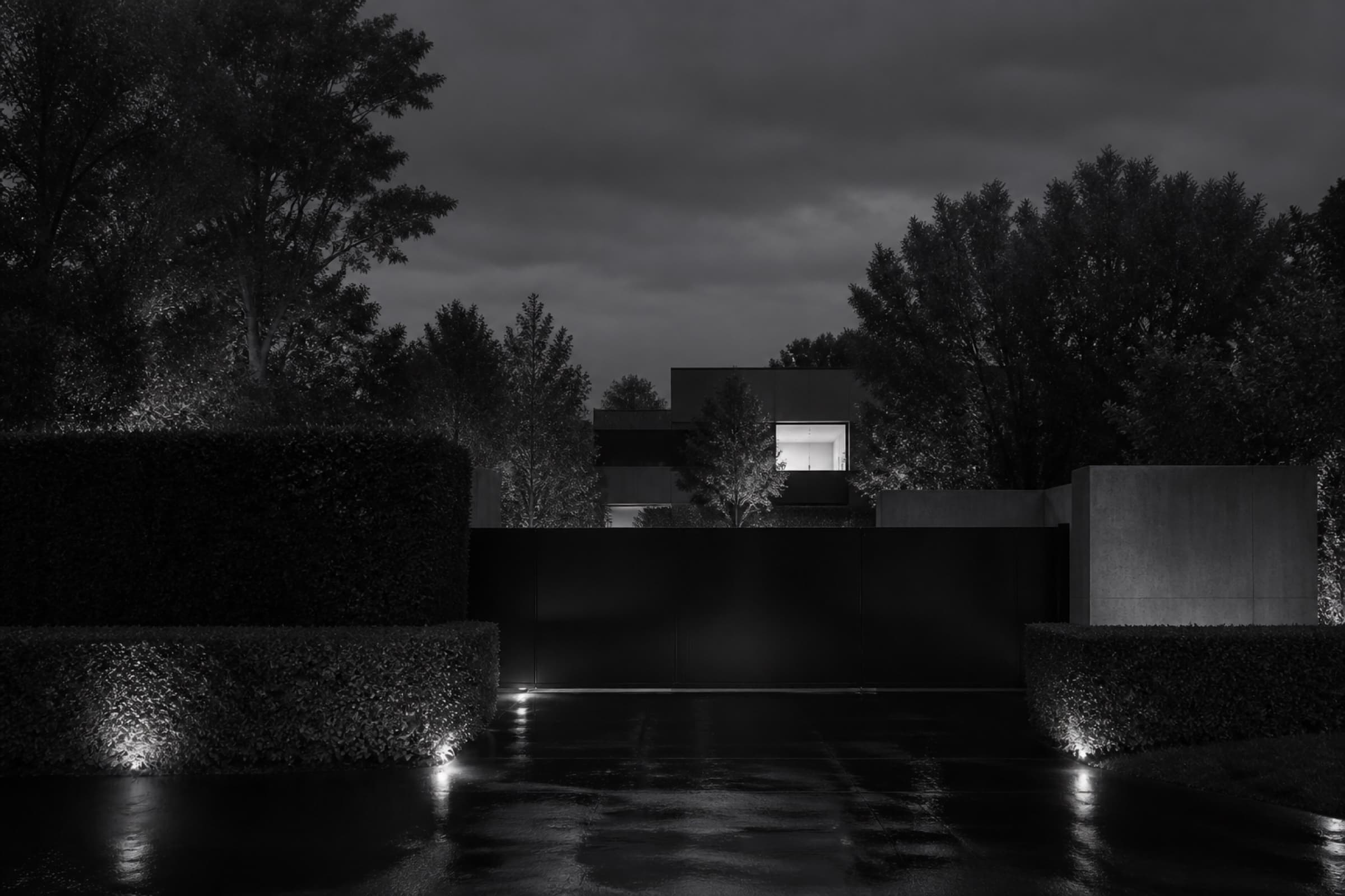 The approach to a private residence at dusk, seen from the perimeter.