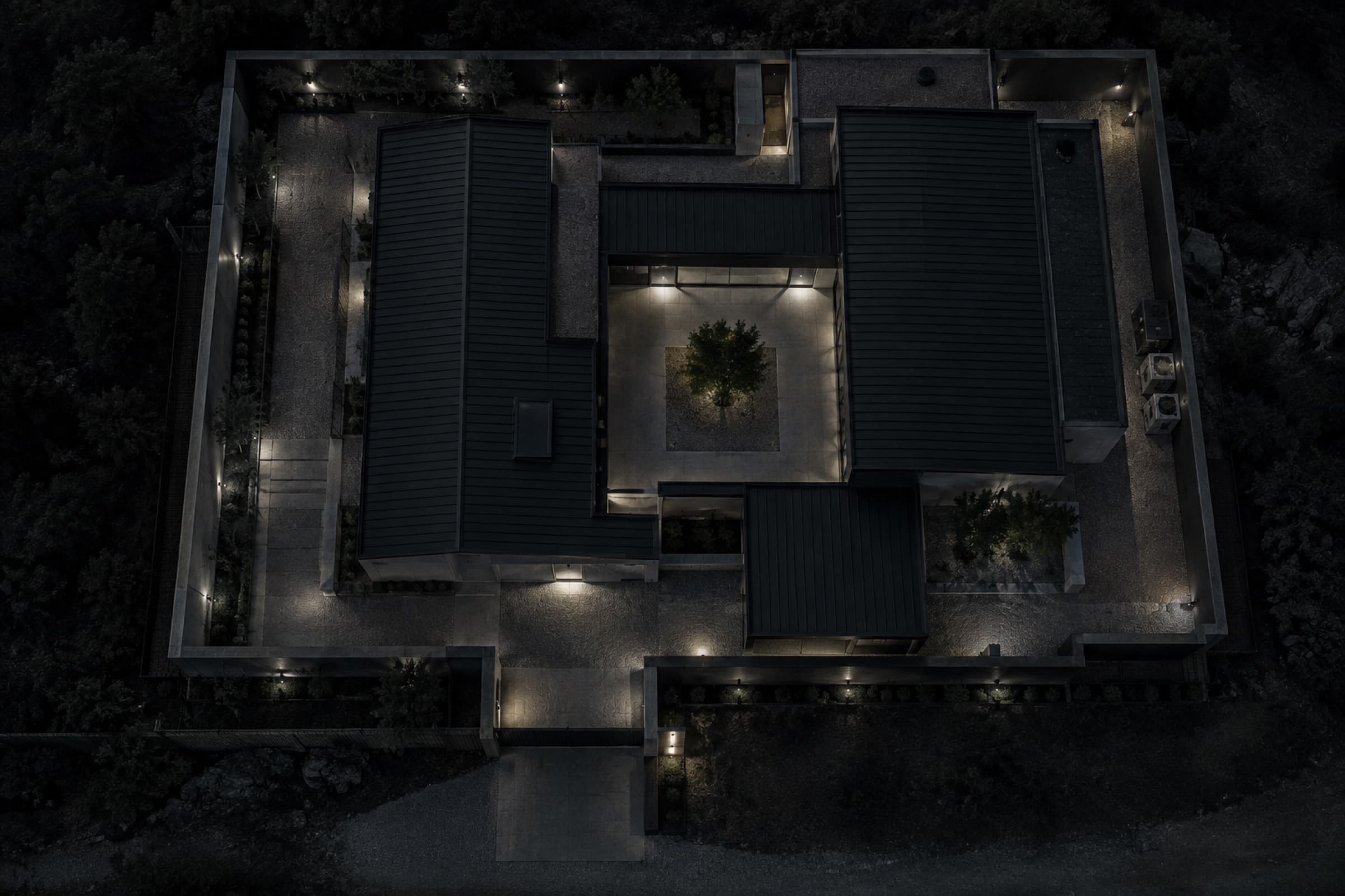 A modern residential courtyard and perimeter viewed vertically at night.